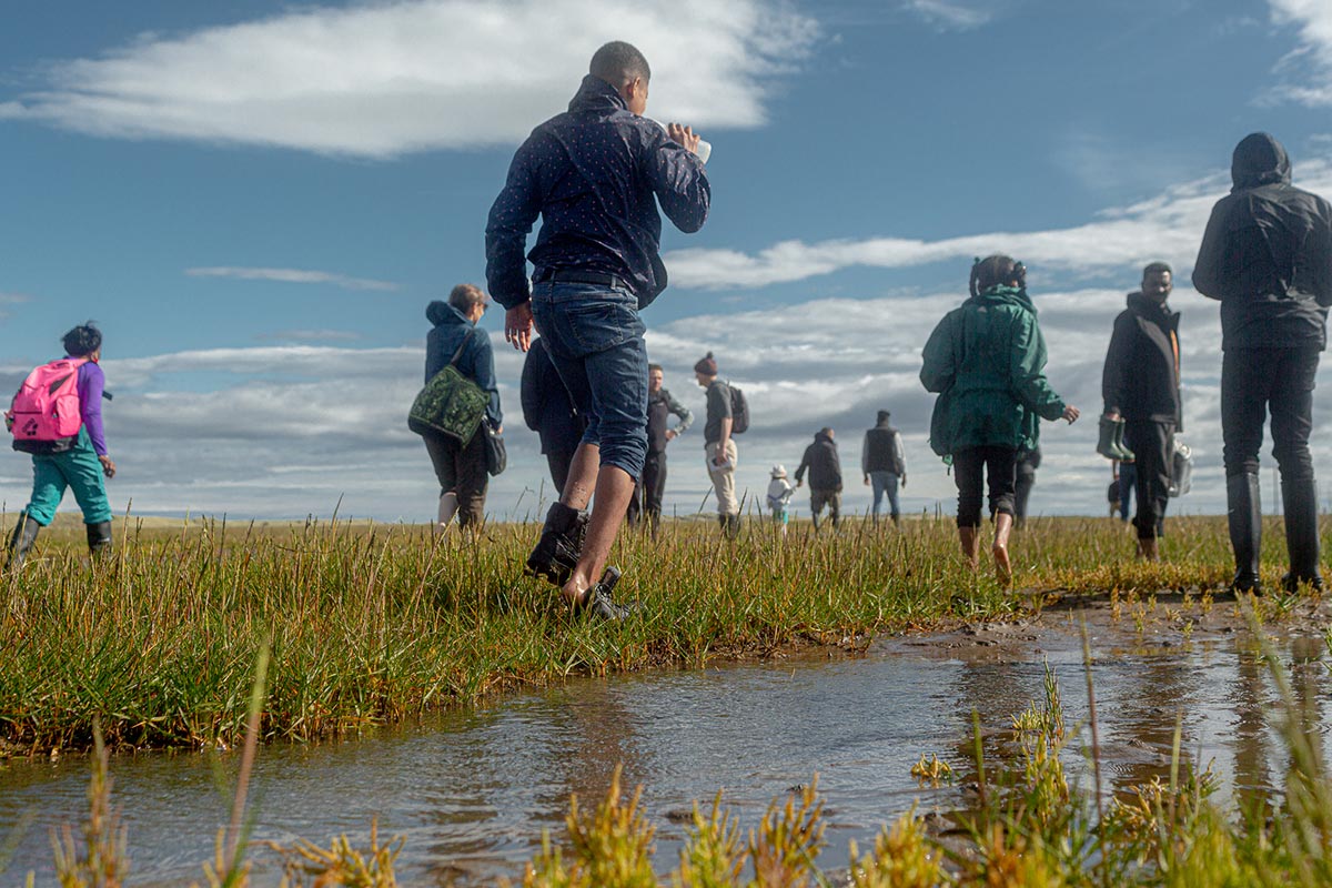A group walking on wet grassland on Pilgrim’s Way.