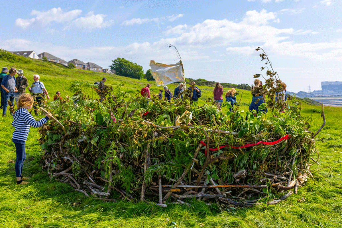 Art installation that consists of swan feathers stitched together, horse harnesses and cotton on a stone surface. 