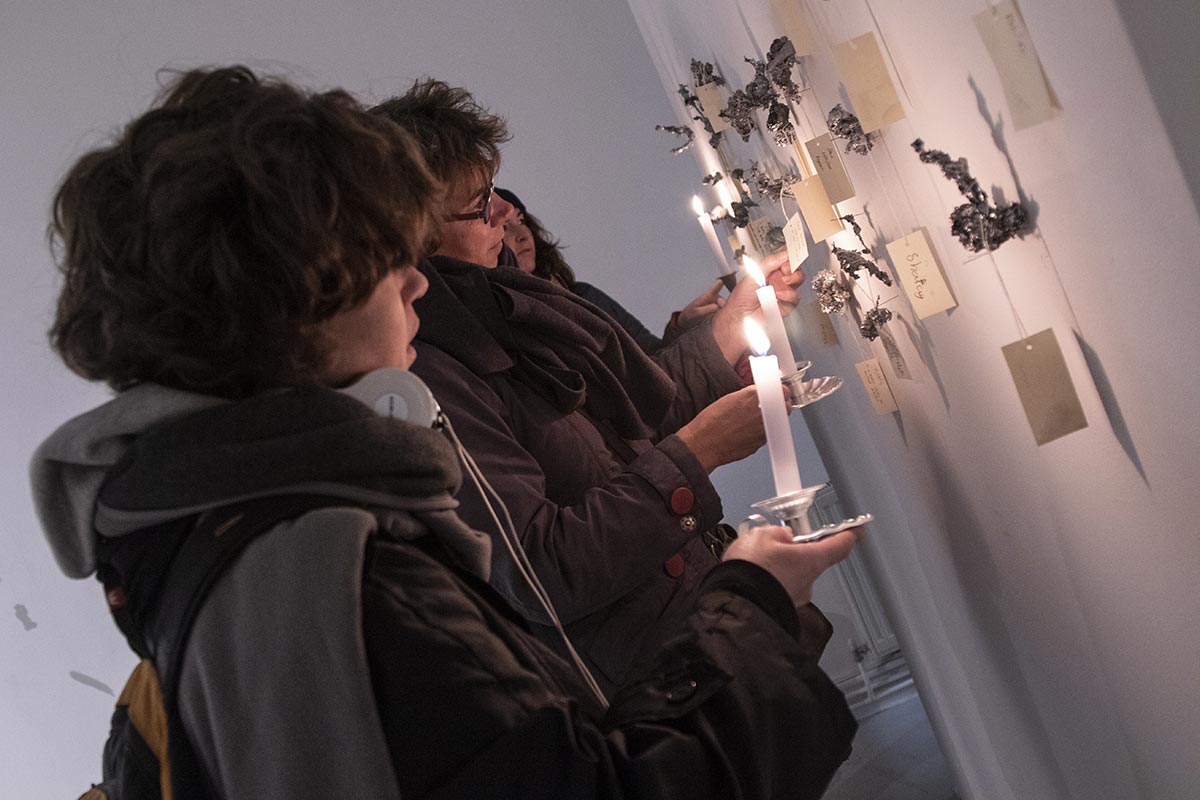 People holding candles and looking at the Omens installation at BALTIC 39.