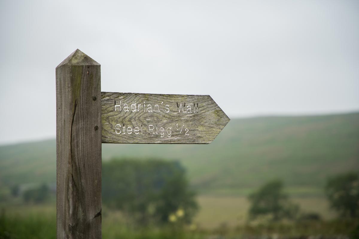 A wooden sign that reads: 'Hadrian’s Wall, Steel Rigg 1/2'.