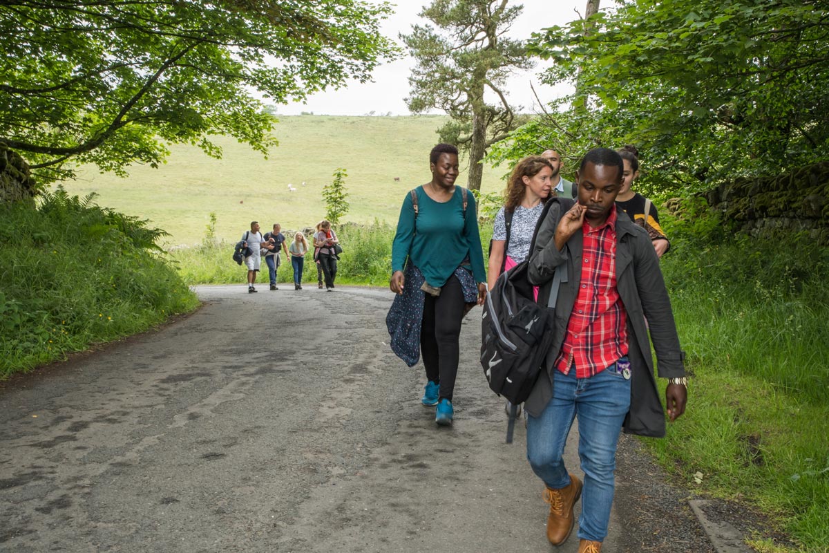 A group walking on a road in Northumberland National Park.